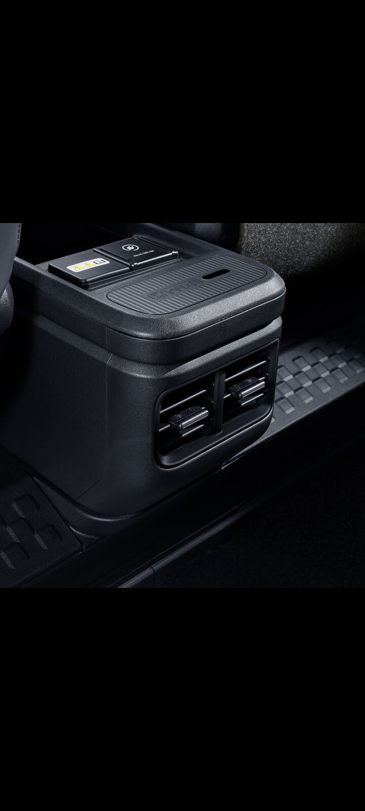 Nahaufnahme der hinteren Lüftungsdüsen in der Mittelkonsole des Kia PV5 Passenger für die zweite Sitzreihe.